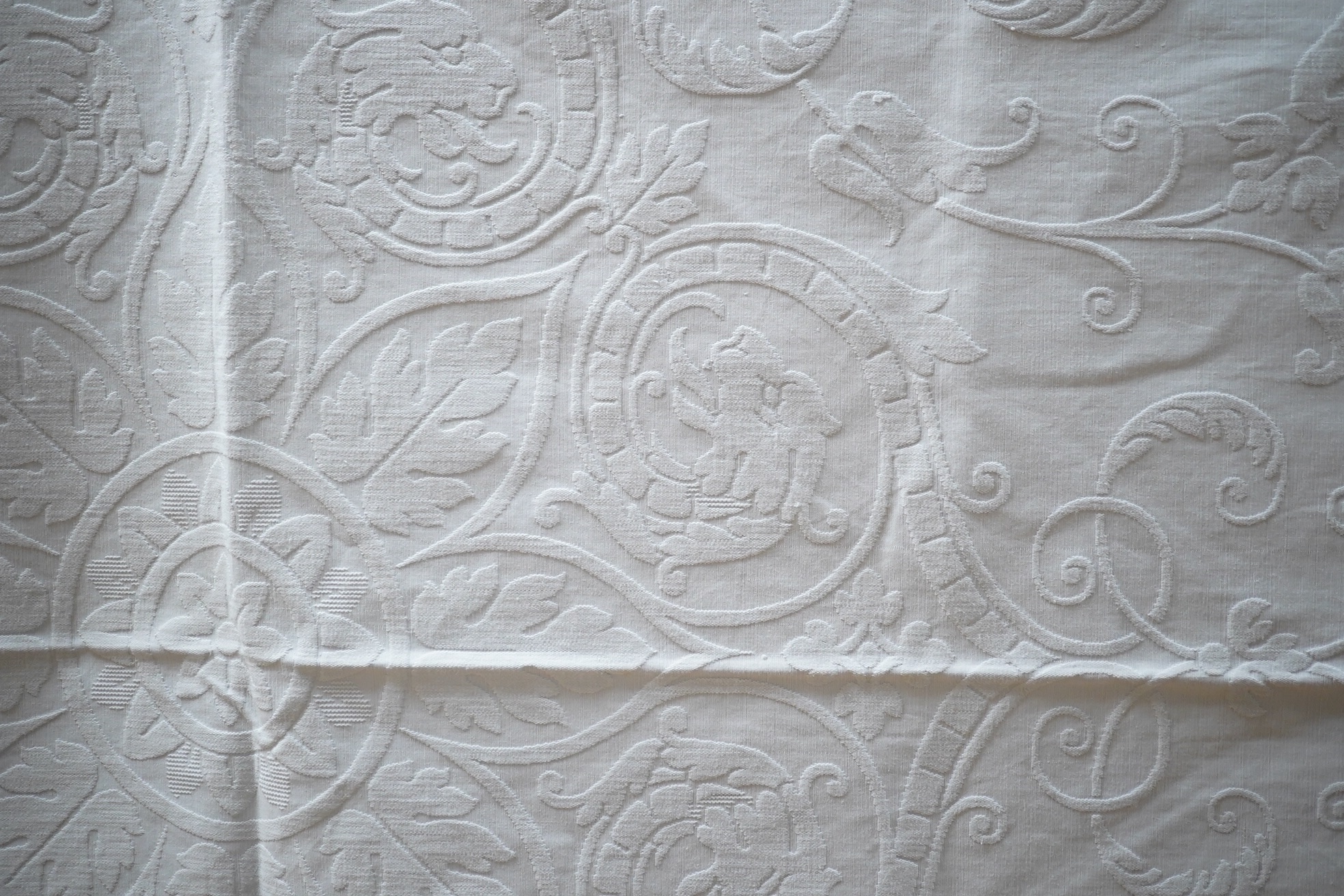 Three inspired Christopher Dresser white linen embossed bedcovers, with wide borders and ornate central designs, 216cm x 208cm. Condition - all good but will need rewashing.